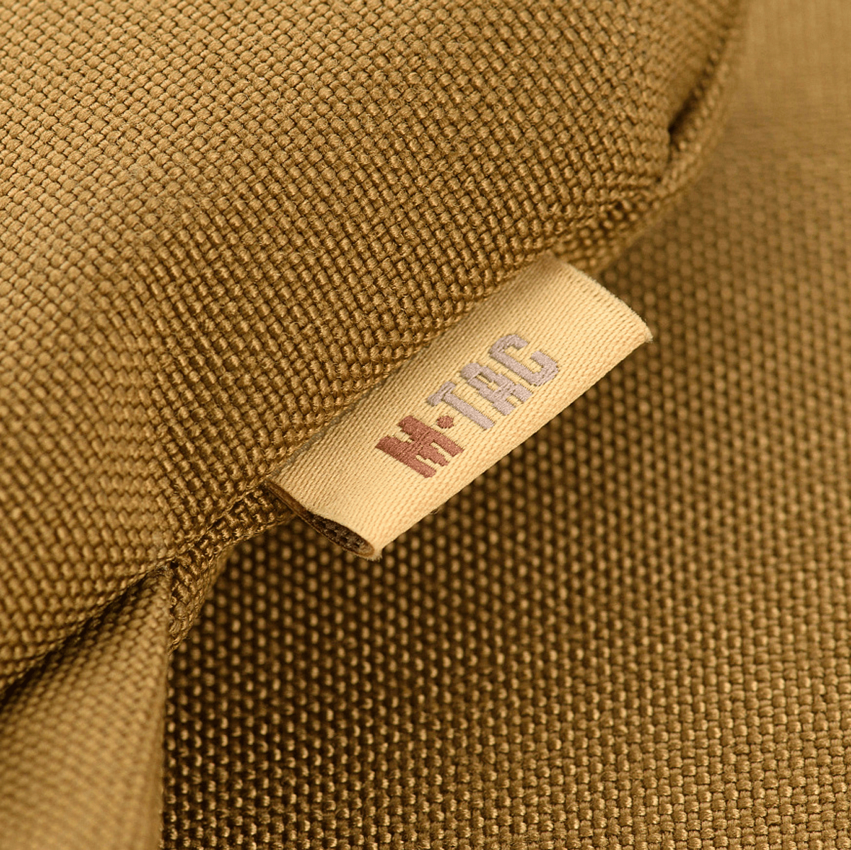 M-Tac Siddeunderlag med bælte i nærbillede, viser detaljerne af mærket.