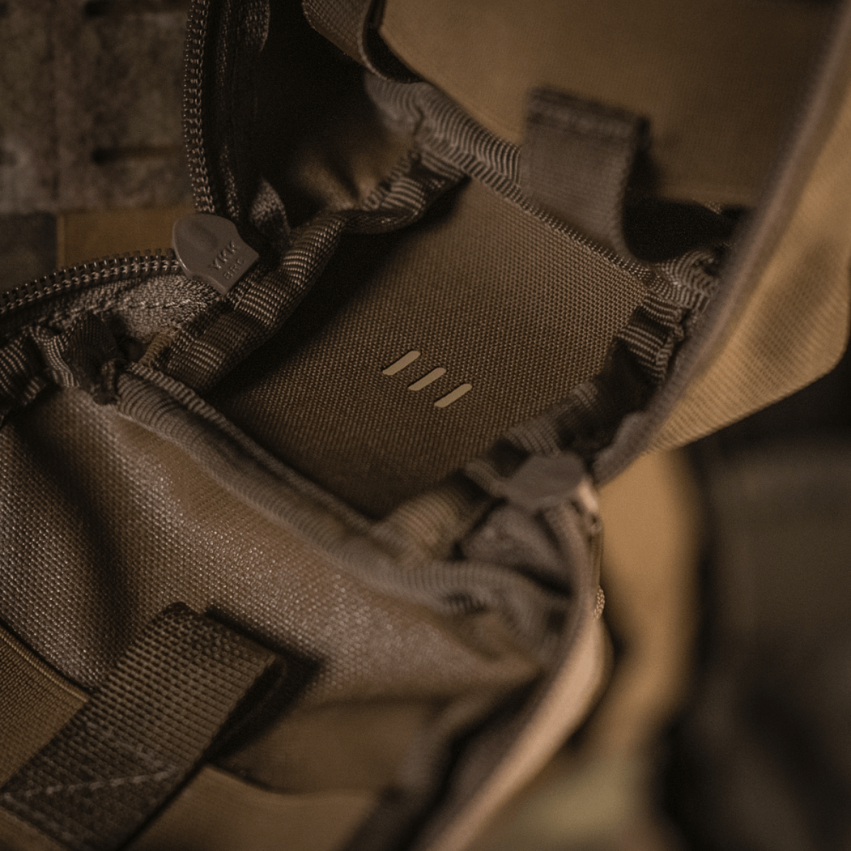 Detaljer af M-Tac Medical Pouch Rip Off med lynlåslukning, monteret på MOLLE Velcro-paneler til hurtig adgang