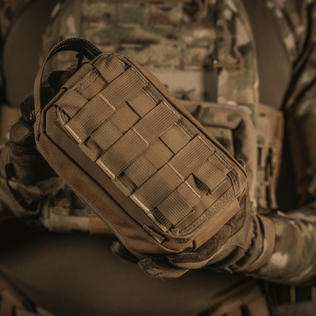 Taktisk brug af M-Tac Medical Pouch Rip Off monteret på MOLLE Velcro-paneler, velegnet til hurtig adgang til førstehjælpskit.