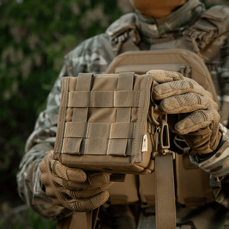 M-Tac Taske til Natkikkert PVS-14 holdt af person i militært udstyr, viser robust design og praktisk størrelse til natkikkertopbevaring.