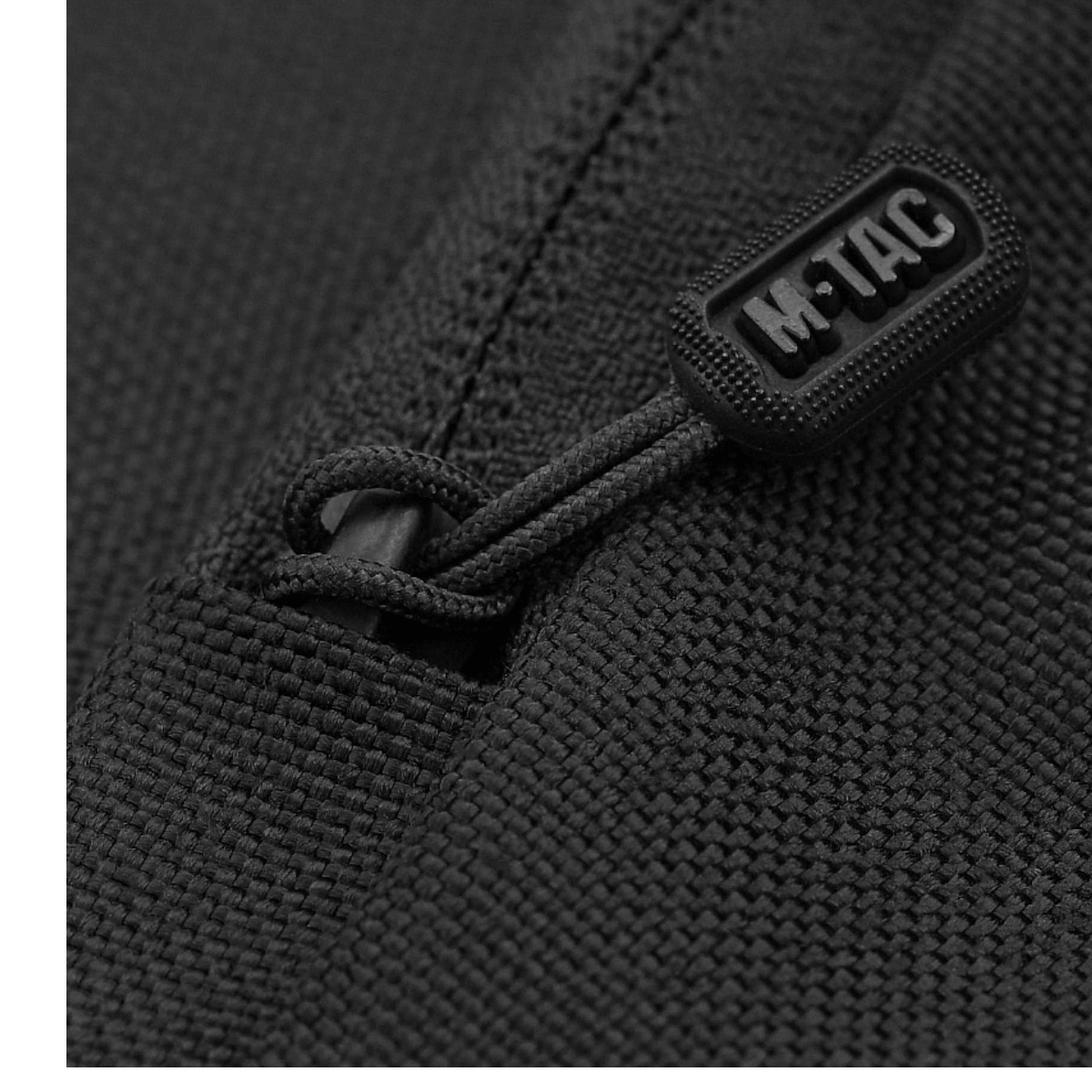 Close-up af M-Tac logo på lynlås af M-Tac Carry Sling Taske Elite Gen.IV i sort, fremhæver taskens elegante design og kvalitet.