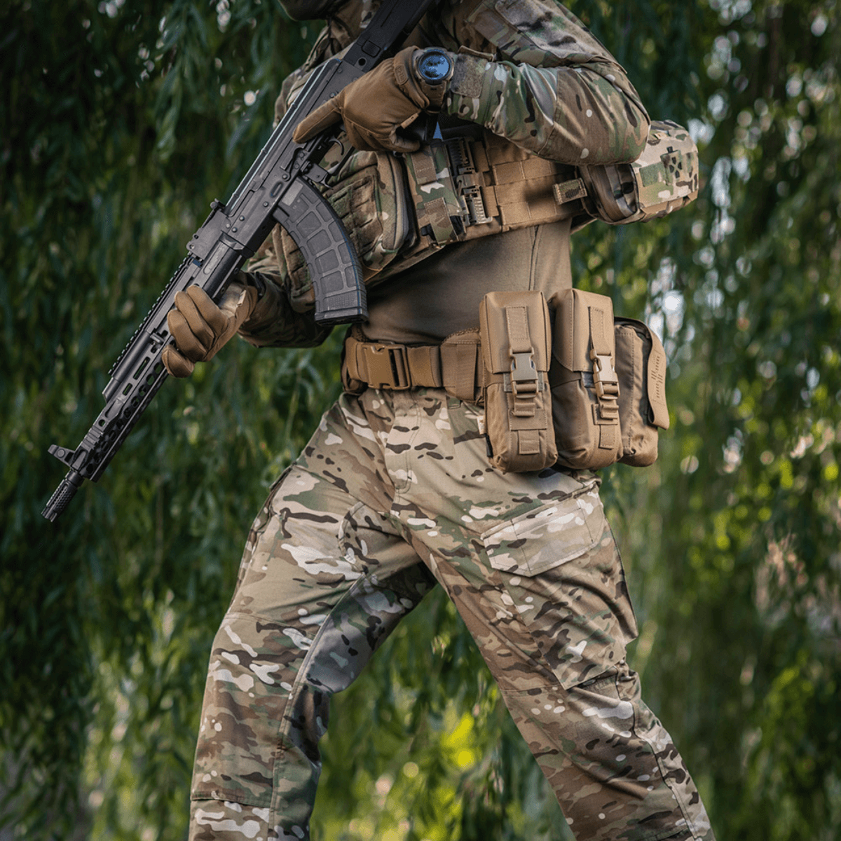 M-Tac War Belt ARMOR båret af taktisk udstyret soldat, viser holdbarhed og MOLLE-system i naturmiljø.