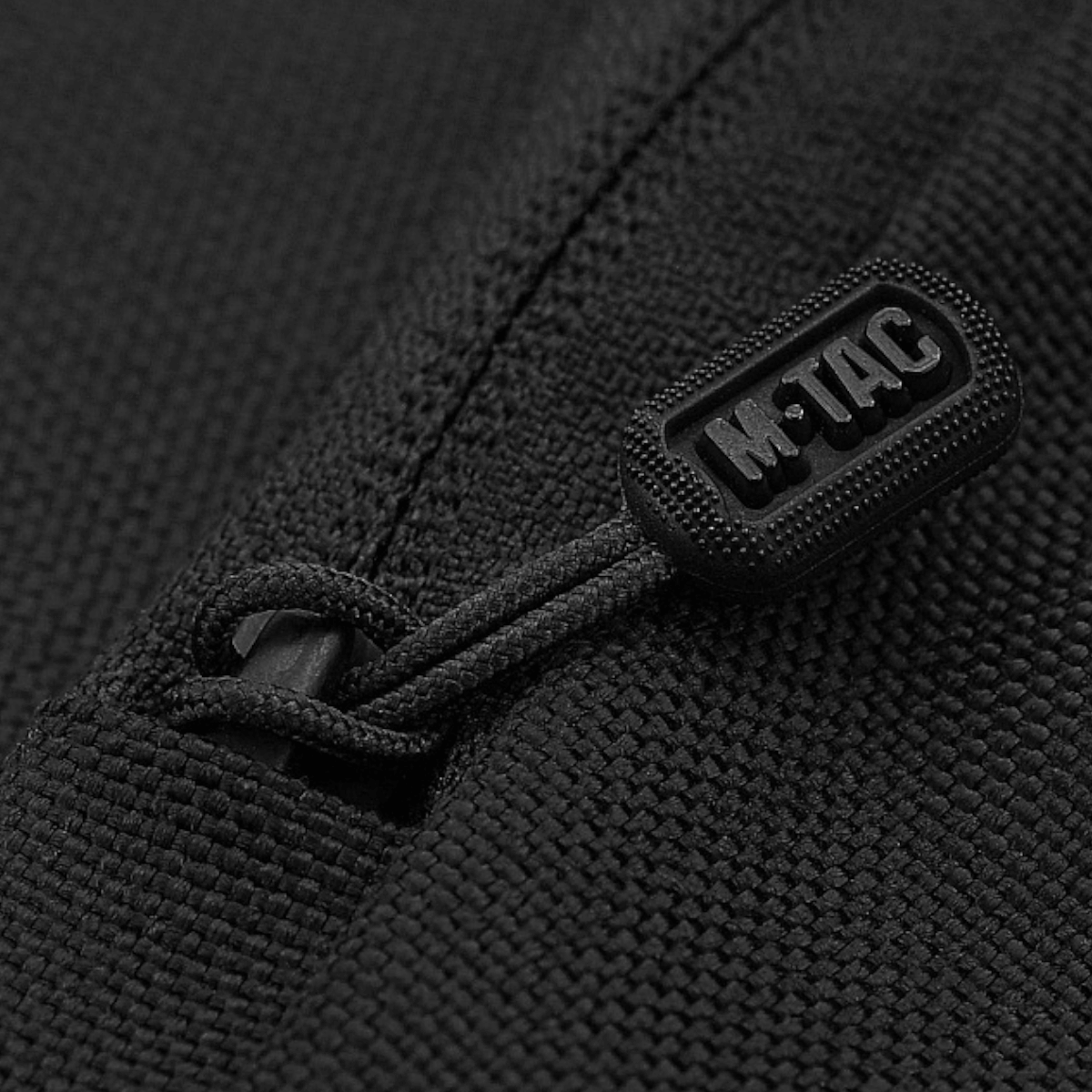 Nærbillede af lynlås på M-Tac Carry Sling Taske Elite Gen.IV med Velcro i sort stof for sikker og diskret våbenopbevaring.