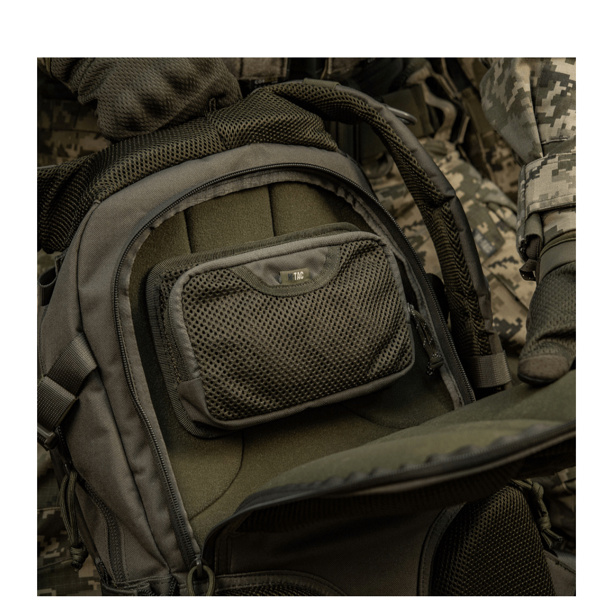 M-Tac Hook & Loop Utility Panel monteret på en rummelig rygsæk med lynlåslomme, velegnet til organisering af småting i tasker.