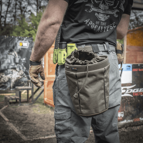 En person bär en M-Tac Mag Drop Pouch Elite monterad på utrustning med MOLLE-fästen för snabb åtkomst till magasin