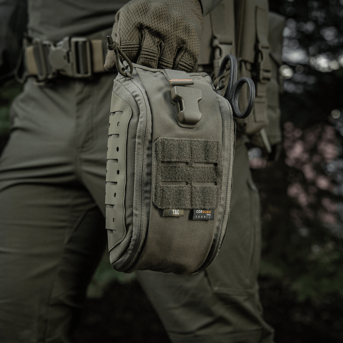 M-Tac Medical Pouch Elite Rip Off i brug til taktisk førstehjælp i felten, med hurtig adgang via træk i håndtaget.