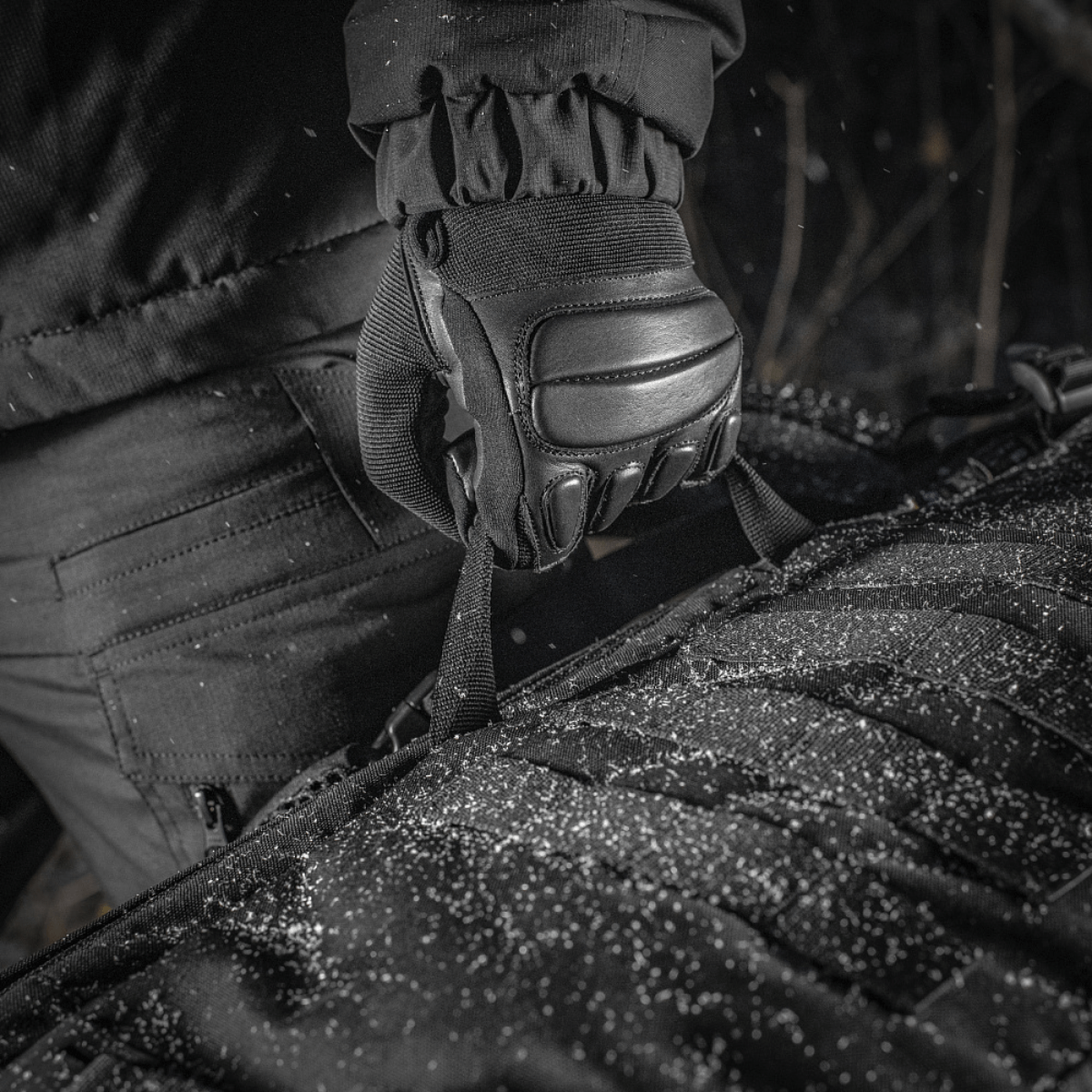 Nærbillede af M-Tac Rygsæk Gen.II Elite Large i Cordura materiale, holdt af handske i snevejr