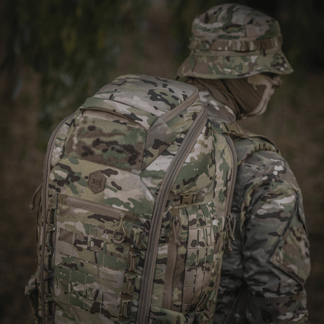 M-Tac Ryggsäck Large Gen.IV Elite i kamouflagedesign används i utomhusmiljö, tillverkad av slitstark Cordura för skydd och hållbarhet.