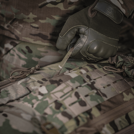 Detaljerad bild av M-Tac Ryggsäck Large Gen.IV Elite under användning, visar hållbart Cordura-material i kamouflagedesign.