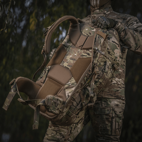 M-Tac Ryggsäck Large Gen.IV Elite i kamouflagemönster, ergonomisk design, hålls av person i militärkläder i naturmiljö.