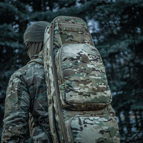 Jägare bär camouflage M-Tac Gun Backpack Case 125 cm Gen.II Elite i skogsområde