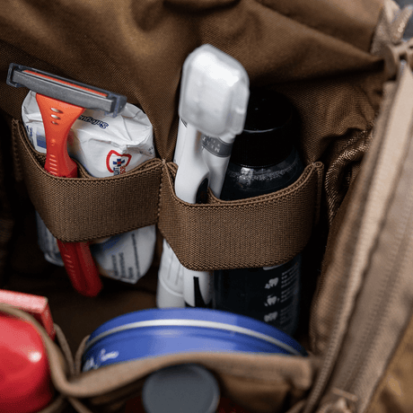 Nærbillede af M-Tac Toilettaske Elite Gen.II med barbermaskine, tandbørste og tandpasta. Kompakt og organiseret opbevaring til hygiejneartikler.