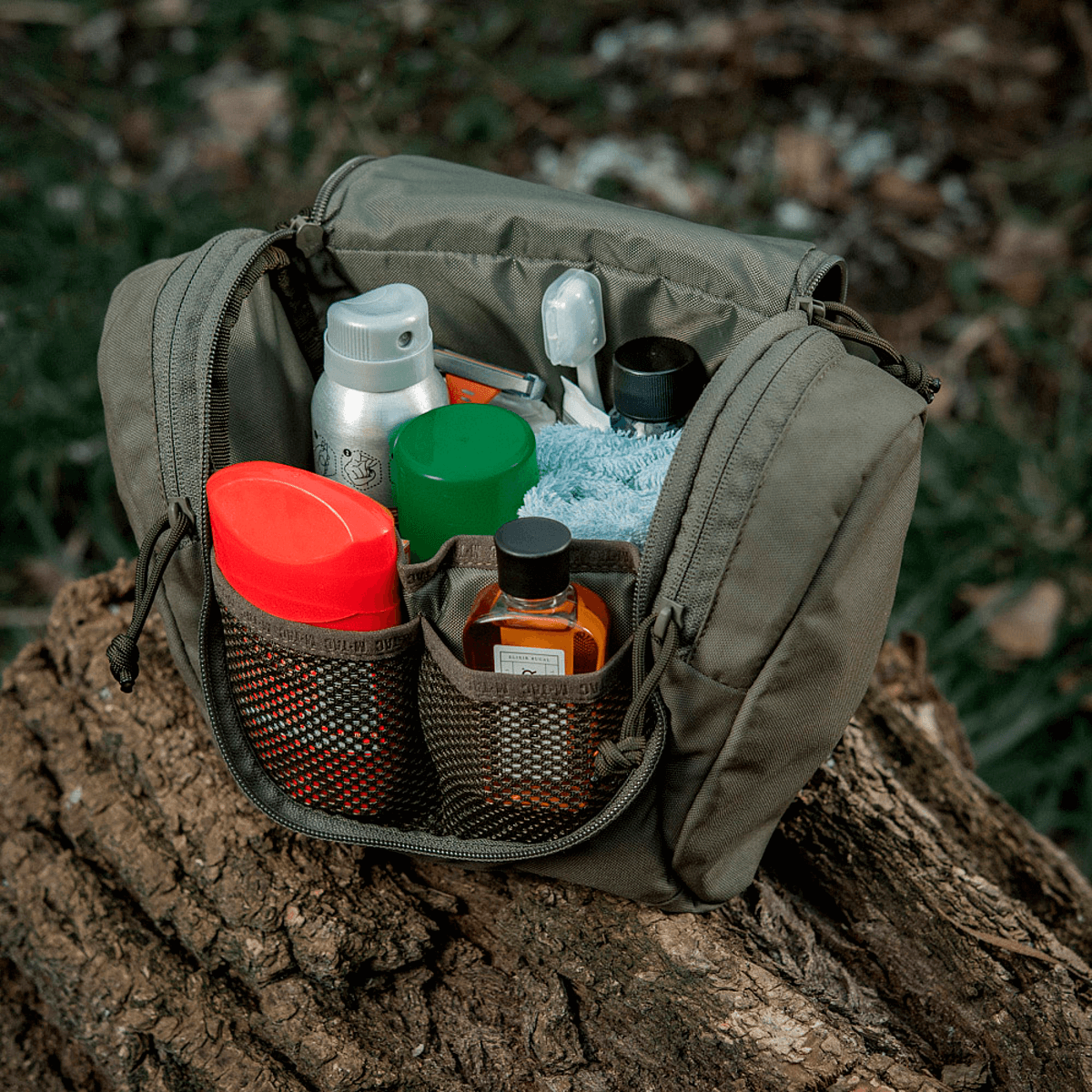 M-Tac Toilettaske Elite Gen.II fyldt med hygiejneartikler som tandbørste, barbermaskine og lotion, perfekt til organiseret opbevaring.