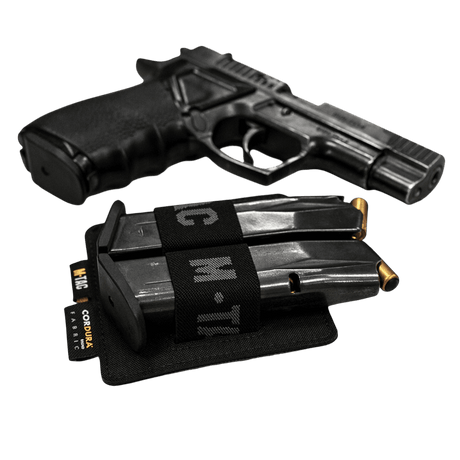 M-Tac Double Mag Pouch Hook Backed Magazine med två magasin bredvid en pistol på svart bakgrund
