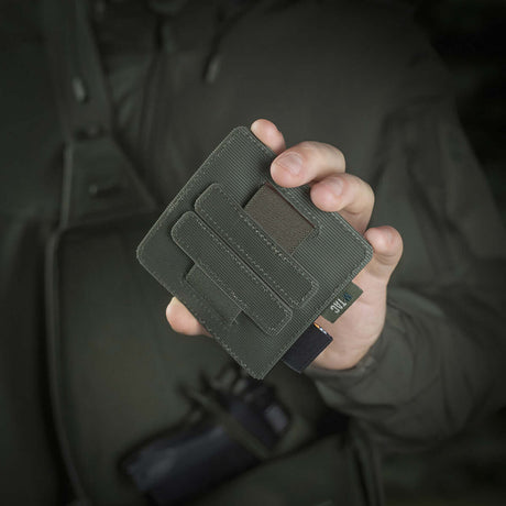 Person håller M-Tac Double Mag Pouch Hook Backed Magazine, perfekt för pistolmagasin och multiverktyg, fäst med Velcro