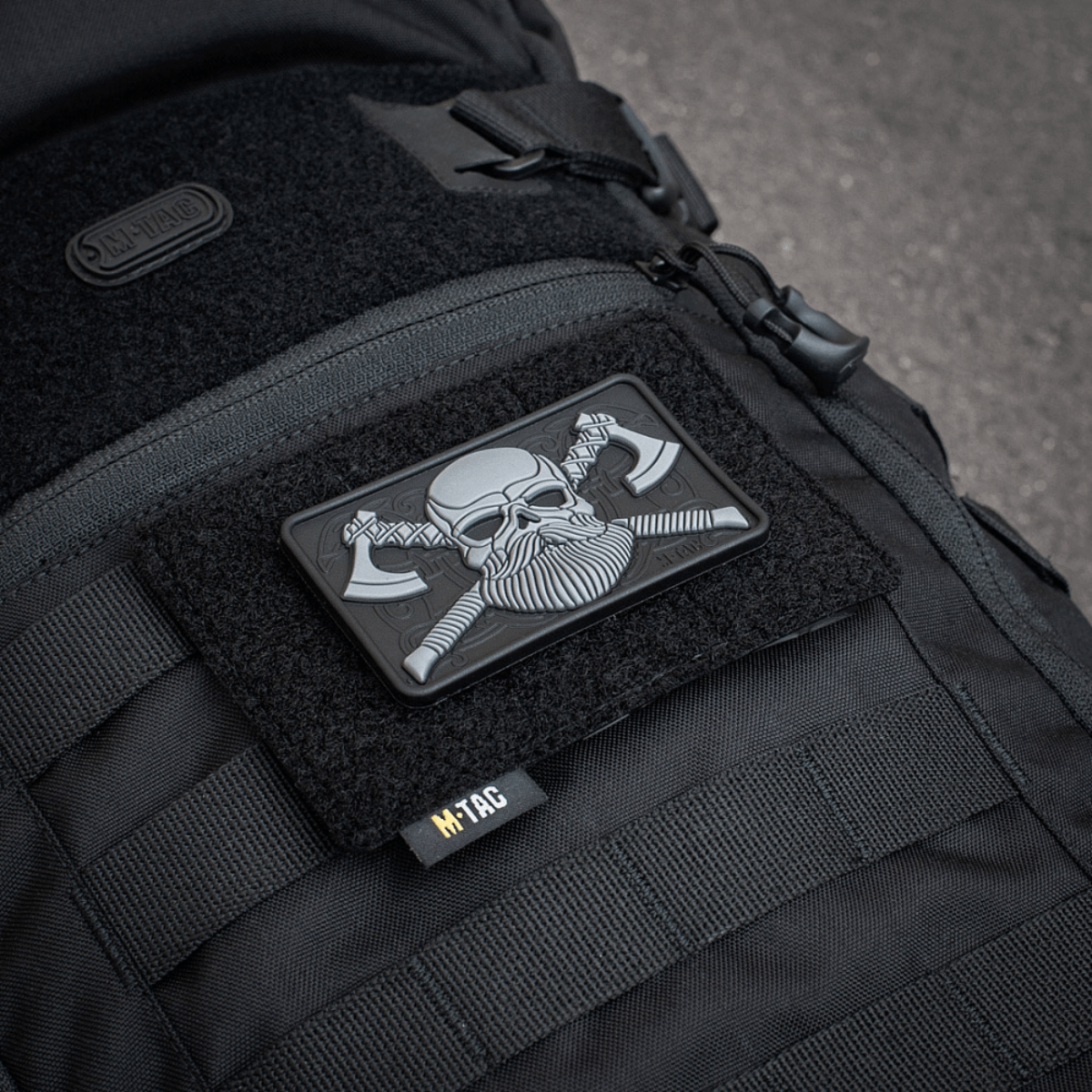 M-Tac Taktisk Morale Patch Display Board Hook og Loop Molle 120x85, monteret på en sort taske med en plastbase til stabilitet.