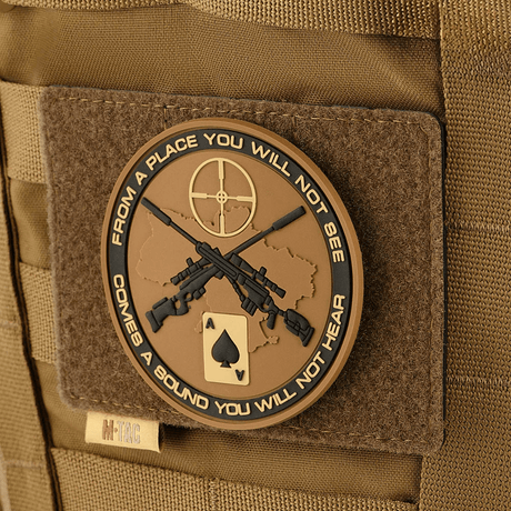 M-Tac Taktisk Morale Patch Display Board Hook og Loop Molle 120x85 med en dekorativ patch fäst i MOLLE-system.