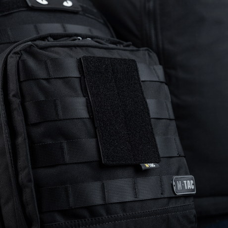 M-Tac panel för patches på MOLLE 80x135 monterad på svart väska med MOLLE-system