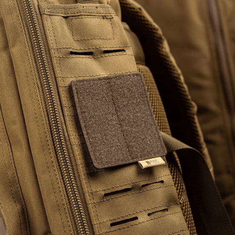 M-Tac panel för patchar på MOLLE 80x85 fäst vid en ryggsäck med hook & loop-ytan, plastbas för stabilitet.