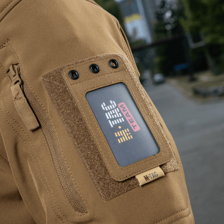 M-Tac taktisk ID-korthållare med snöre på jackärm, robust Cordura-material, lämplig för militärt och taktiskt bruk, 'M-TAC TEAM' märke synligt.