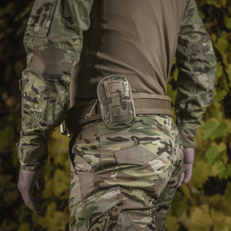 M-Tac PC Utility Pouch Elite monterad på bälte, MOLLE-system, camoufagemiljö, tillverkad i slitstark 500D Cordura. Perfekt för taktisk användning