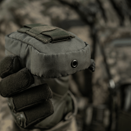 M-Tac PC Utility Pouch Elite i Cordura med MOLLE-interface, hålls av person i taktisk utrustning, idealisk för små förvaringsuppgifter