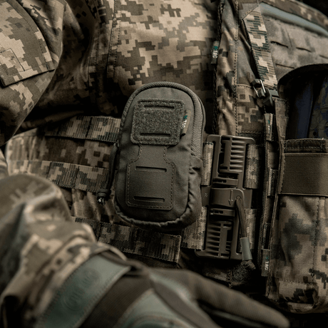 M-Tac PC Utility Pouch Elite monterad på taktisk väst med MOLLE-interface och Velcro-panel, idealisk för förvaring och dränering i botten