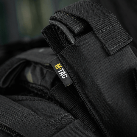 M-Tac Tourniquet Pouch Elastisk med MOLLE Gen.II i svart Cordura-tyg, fäst vid utrustning med MOLLE-system.