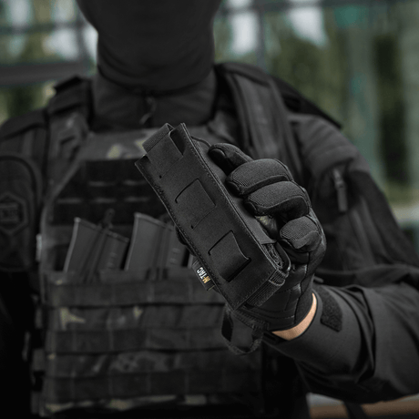 M-Tac Tourniquet Pouch Elastisk med MOLLE Gen.II i användning, hålls av person i taktisk utrustning, ger snabb åtkomst.