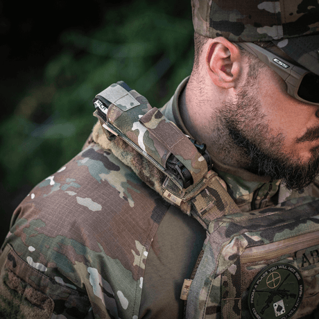 Soldat bär M-Tac Tourniquet Pouch Elastisk med MOLLE Gen.II för snabb åtkomst och säker förvaring av tourniquet på MOLLE-utrustning.