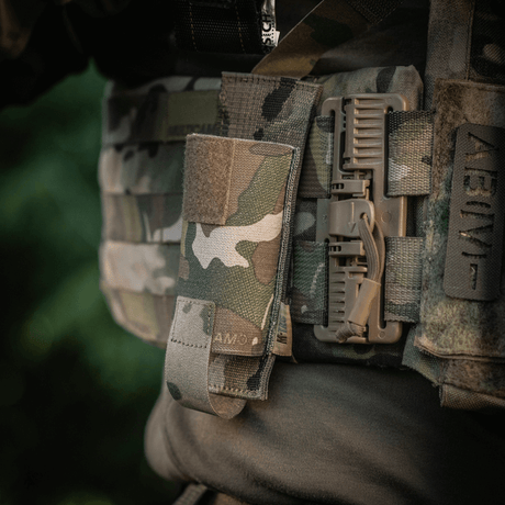 M-Tac Tourniquet Pouch Elastisk med MOLLE Gen.II fäst på utrustning med kamouflagedesign.