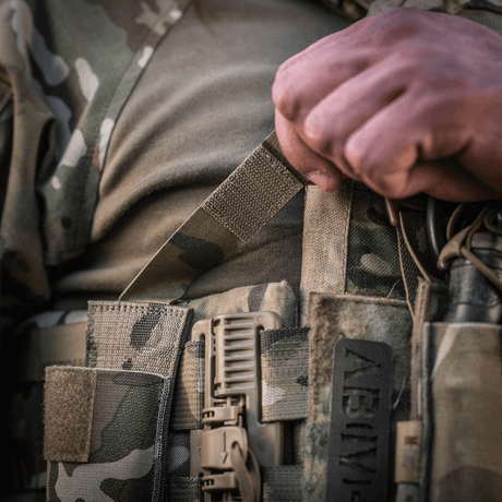 M-Tac Tourniquet Pouch Elastisk med MOLLE Gen.II i bruk, närbild på kamouflageutrustning. Idealisk för snabb åtkomst till tourniquet.