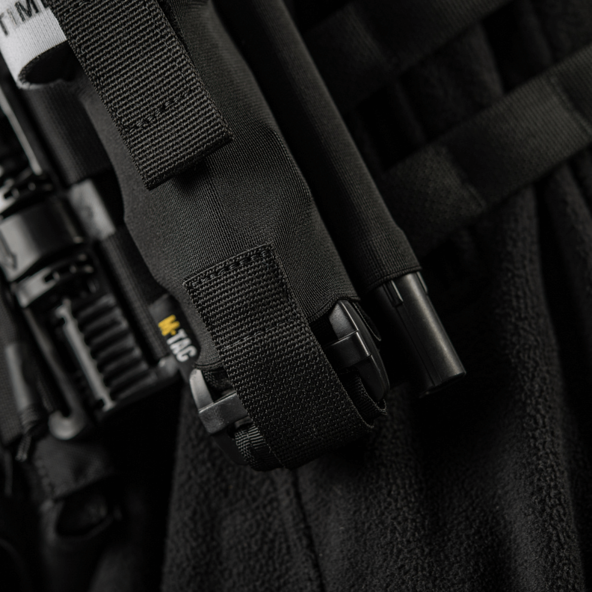 M-Tac Elastisk Tourniquet Pouch Molle Gen.III monteret på uniform, holdbar taske til C-A-T tourniquet, hurtig adgang og sikker fastgørelse.