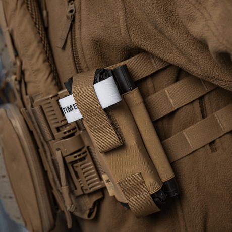 M-Tac elastisk tourniquetficka Molle Gen.III fäst på utrustning, med elastik och nylon för snabb åtkomst och säker förvaring av tourniquet.