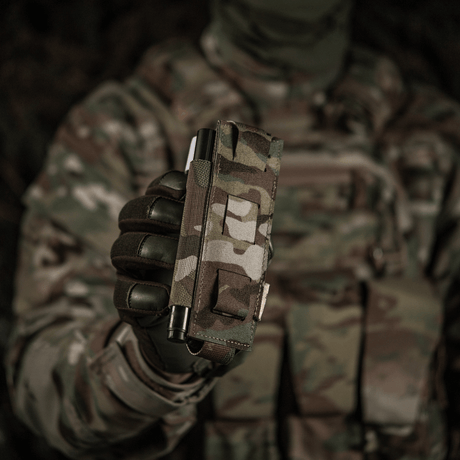 Soldat med M-Tac Elastisk Tourniquet Pouch Molle Gen.III i kamouflageuniform, för C-A-T tourniquet, 15x5 cm, snabb åtkomst.