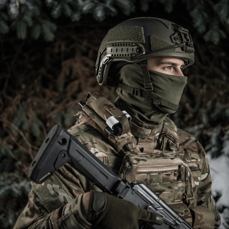 Soldat iklädd taktisk utrustning med gevär i vintermiljö