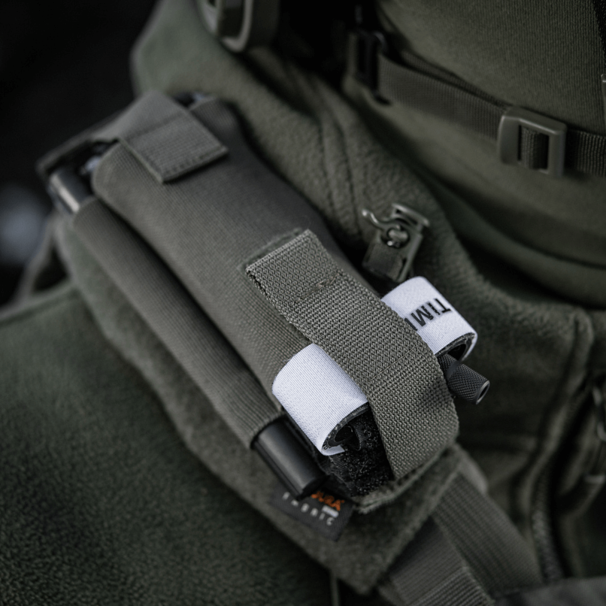 M-Tac Elastisk Tourniquet Pouch Molle Gen.III monteret på jakke, lavet af Cordura Squadron, med bred elastik til C-A-T tourniquet.