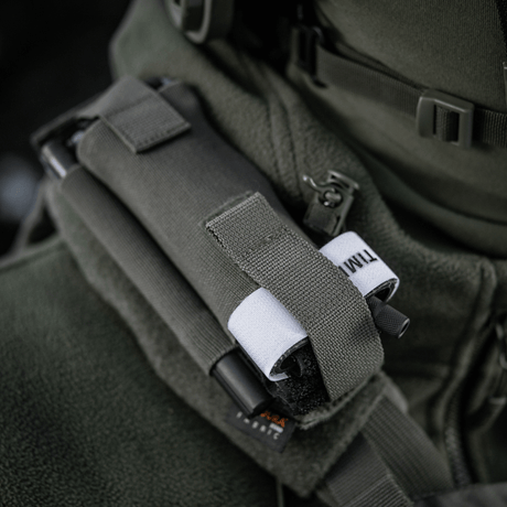 M-Tac elastisk tourniquetficka Molle Gen.III monterad på jacka, gjord av Cordura Squadron, med bred elastik för C-A-T tourniquet.