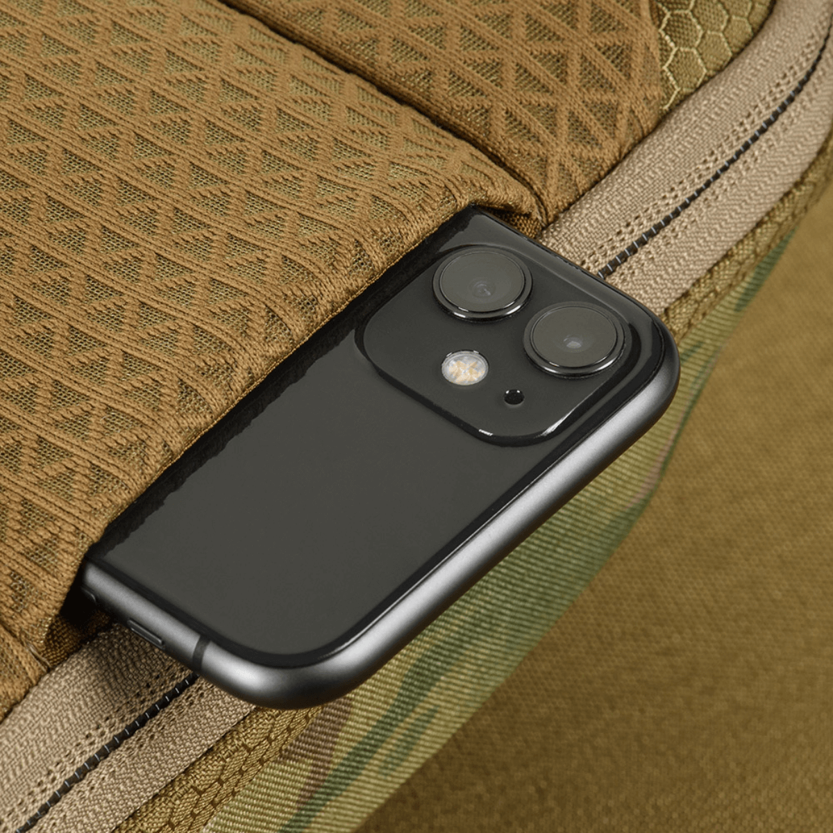 Detaljebillede af en smartphone i M-Tac Sphaera Hex Hardsling Taske Gen.II Elite, fremhæver funktionalitet og stil.