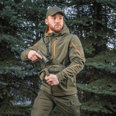 Man bär M-Tac Sphaera Hex Hardsling-väska Gen.II Elite i skogen, redo för snabb insats med dolt bärsystem.