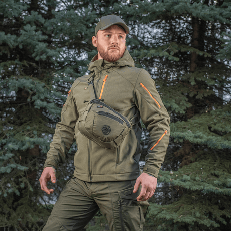 Man bär M-Tac Sphaera Hex Hardsling-väska Gen.II Elite i skogsområde.