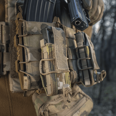 M-Tac Pistol Mag Pouch Gen.3 i Cordura 500D med MOLLE-monteringssystem och elastik för justerbar fastsättning av magasin i skogsmiljö.