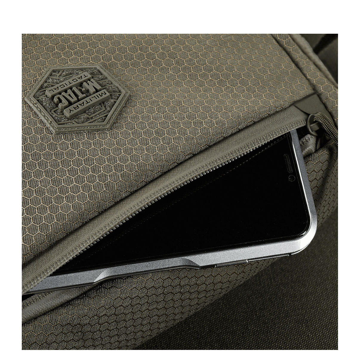 Detalje af M-Tac Magnet XL Taske Elite Hex med FidLock låsesystem og Velcro-panel, vist med opbevaring af smartphone.