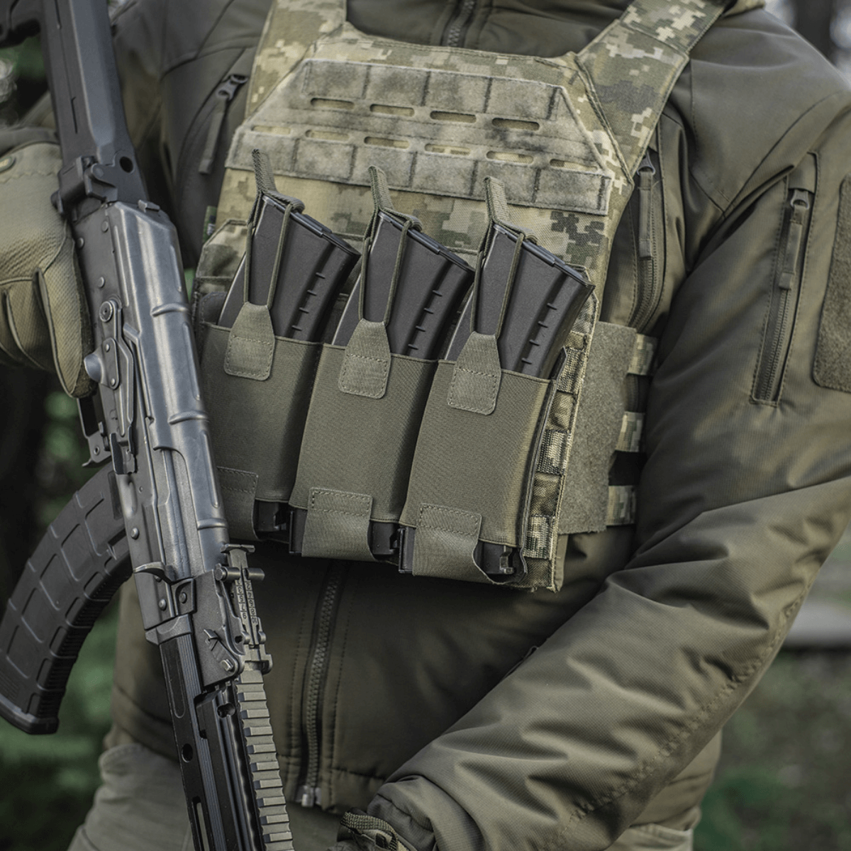 Person iført taktisk vest med M‑Tac Elastisk Triple Magazine Pouch Elite monteret og AK-magasiner indsat.