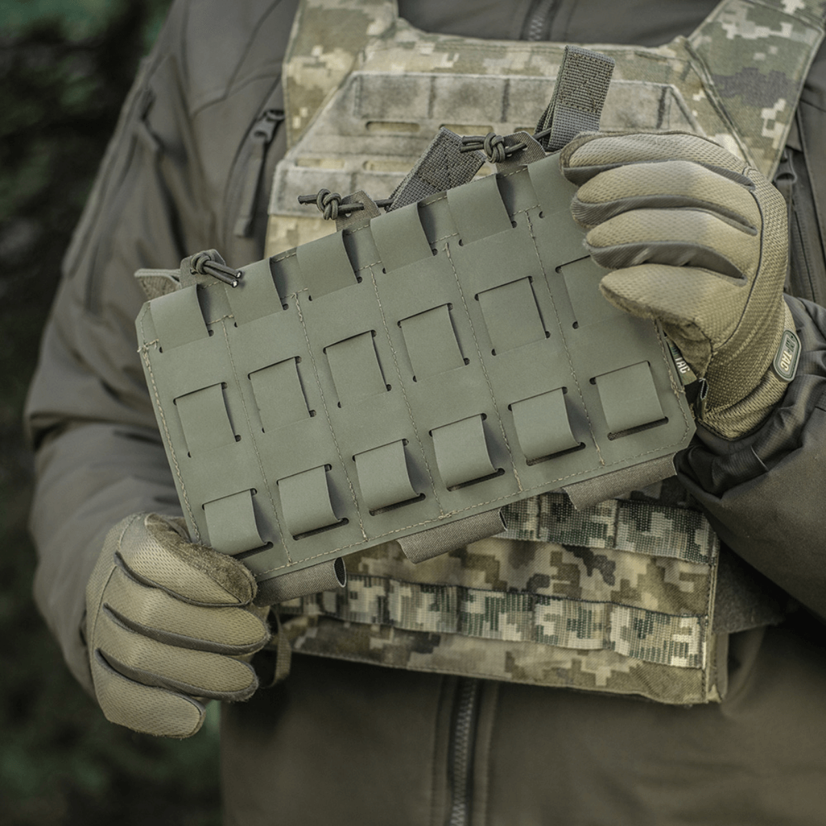 M‑Tac Elastisk Triple Magazine Pouch Elite i brug, monteret på taktisk udstyr med MOLLE. Sikker opbevaring og hurtig adgang til magasiner.