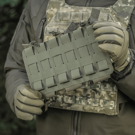 M‑Tac Elastisk Triple Magazine Pouch Elite i användning, monterad på taktisk utrustning med MOLLE. Säker förvaring och snabb åtkomst till magasin.