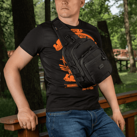 Man som bär M‑Tac Cross Bag Elite Hex, en slingpack av Cordura 500, perfekt för daglig användning och taktisk utrustning.
