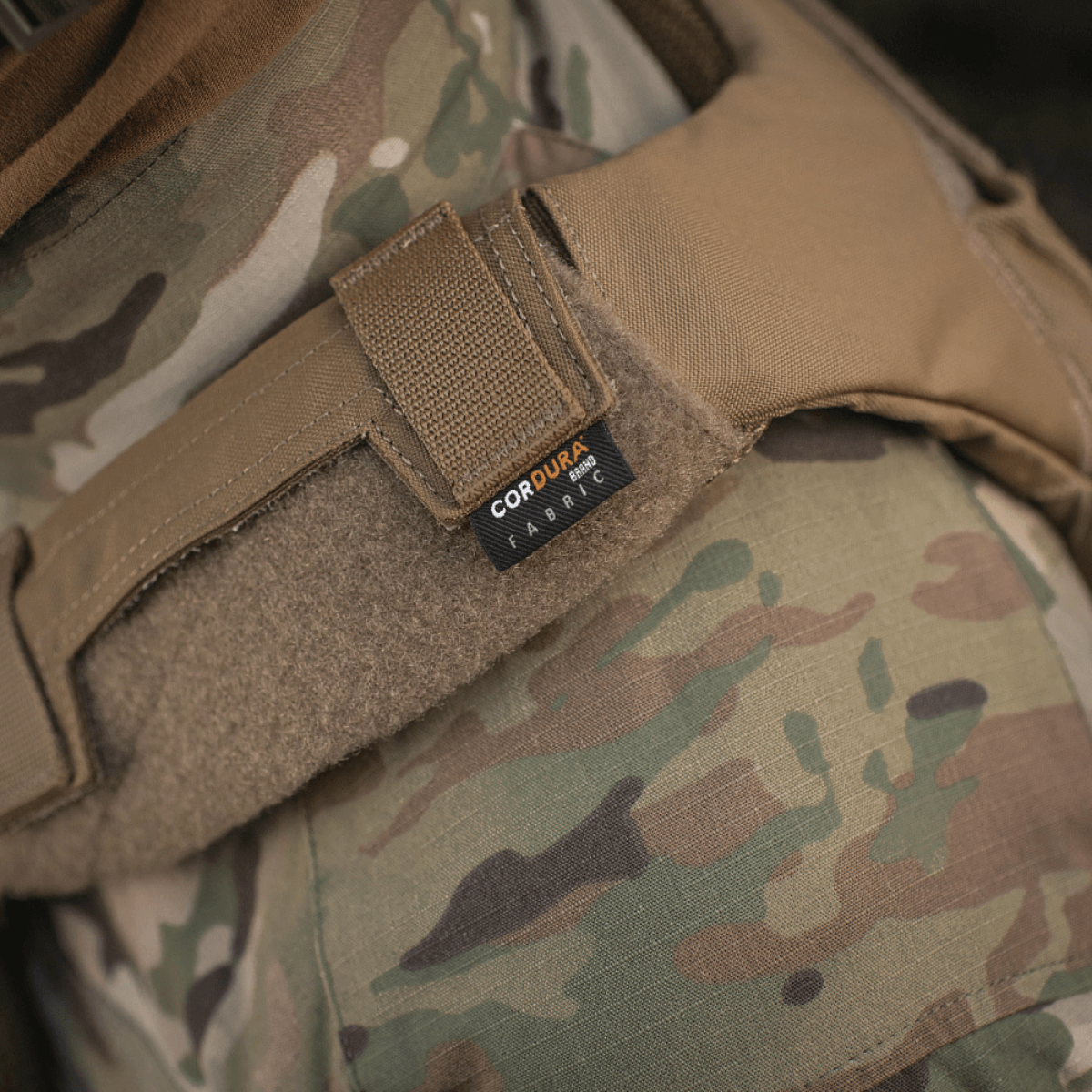 Detaljeret billede af M‑Tac Plate Carrier Cuirass QRS Gen.II med camo-mønster og Cordura 500D materiale på skulderremmen.