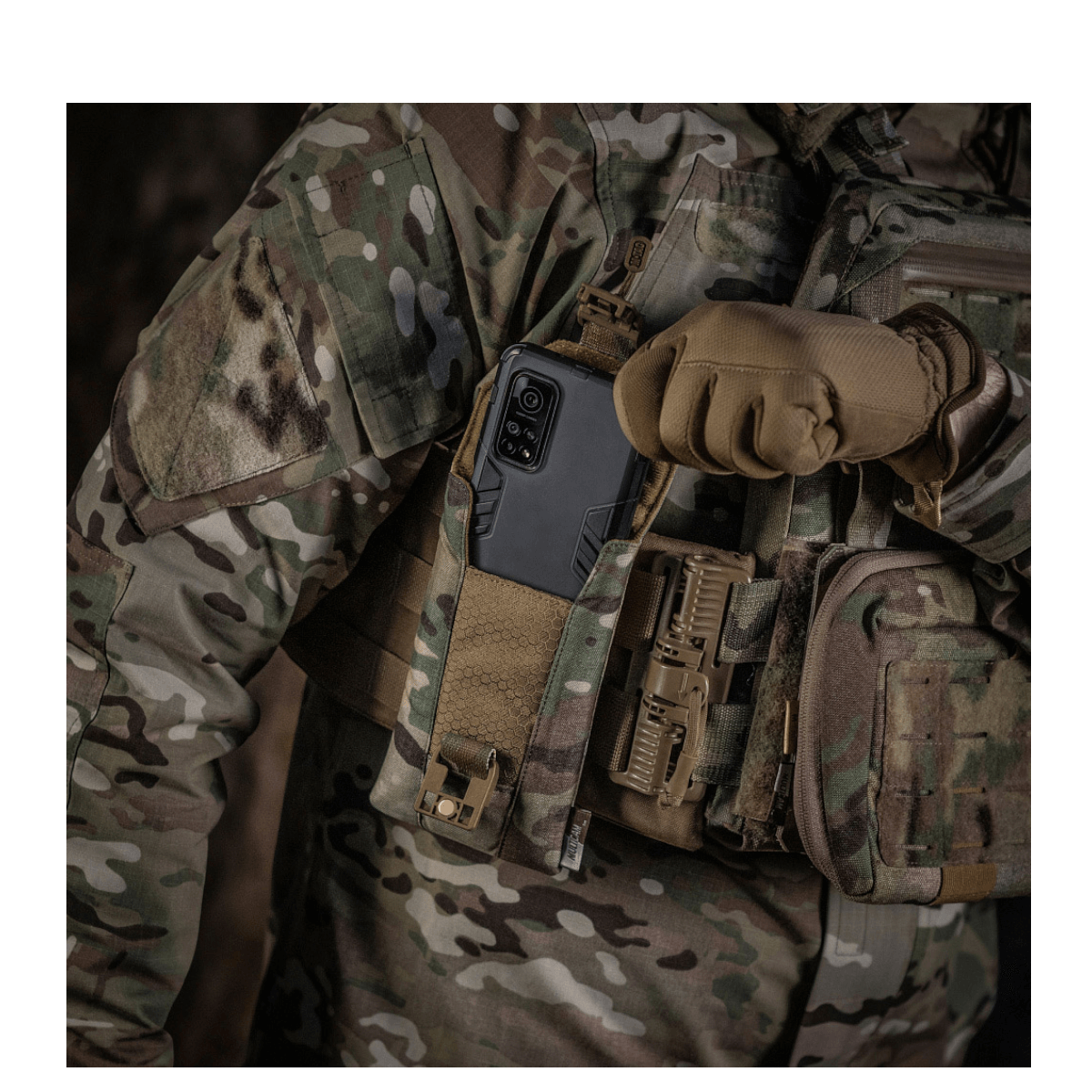 M-Tac Smartphone Lomme Elite Large Hex med smartphone op til 6,5 tommer i camouflagetøj i militærsetting.