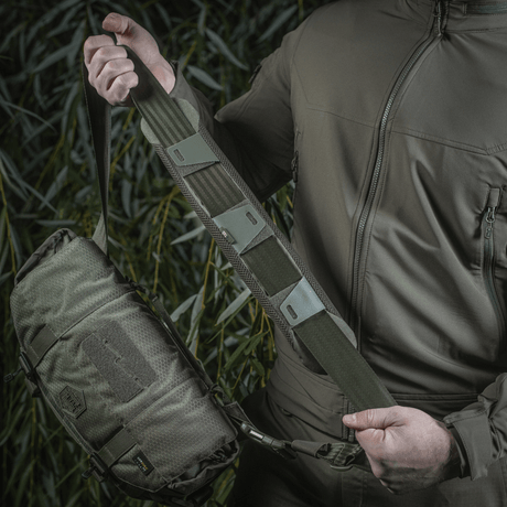 Man håller M-Tac axelremspad 50 mm Elite monterad på väska.